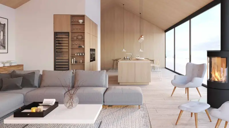 Jasny, przestronny salon z aneksem kuchennym w stylu skandynawskim. Drewniane wykończenia, duża sofa i kominek tworzą przytulną atmosferę.