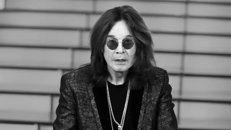 Ozzy Osbourne w okularach i błyszczącej marynarce, z naszyjnikami. Plotki o tym, że Ozzy Osbourne nie żyje, są fałszywe.