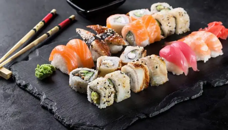 Różnorodne sushi: nigiri z łososiem, tuńczykiem i krewetką, rolki z węgorzem i awokado. Inspiracja do przepisów na sushi.