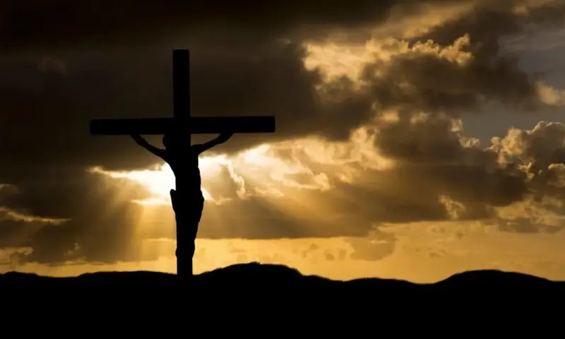 Silhouette of Jesus on the cross against a dramatic sky. His sacrifice shows Jesus died for our sins, offering hope.