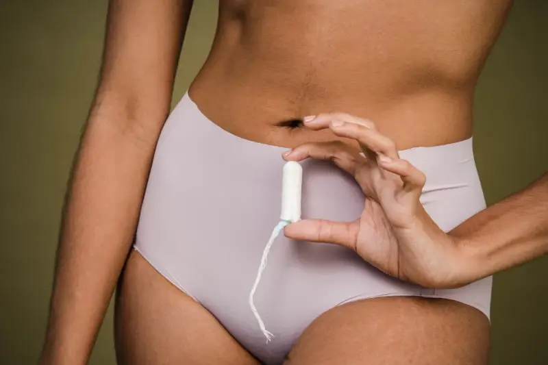 Mano sostiene un tampón. ¿Buscas cómo adelantar la regla?
