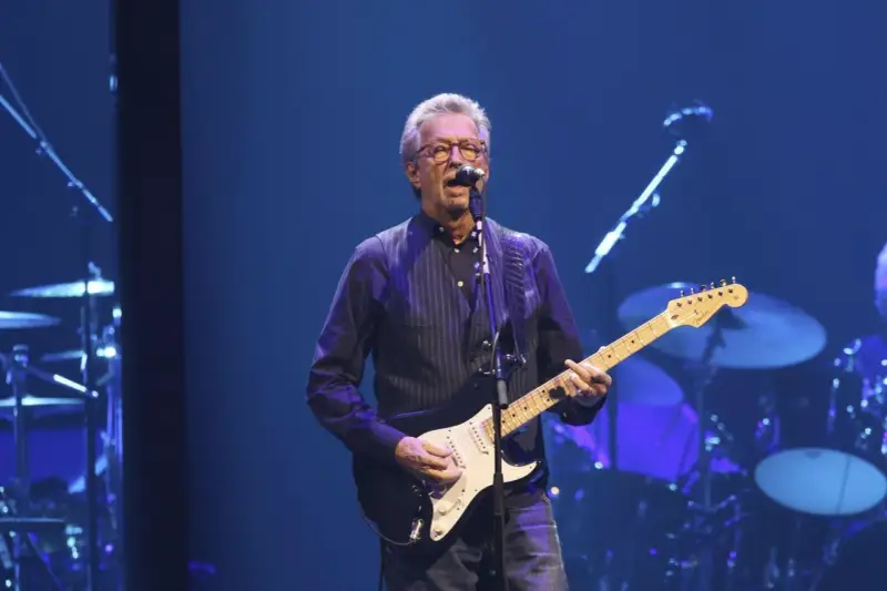 Eric Clapton gra na gitarze, wykonując swoje legendarne utwory.