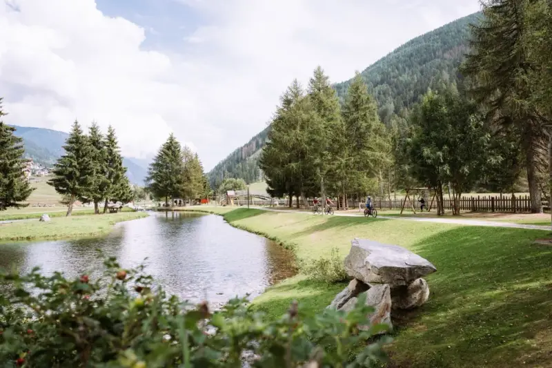 Passeggiata in bici ai laghetti di San Leonardo, tra alberi e montagne.