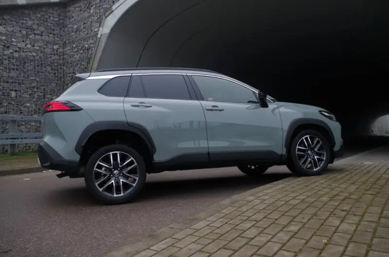 Szary Toyota Corolla Cross hybrydowa stoi na tle tunelu.