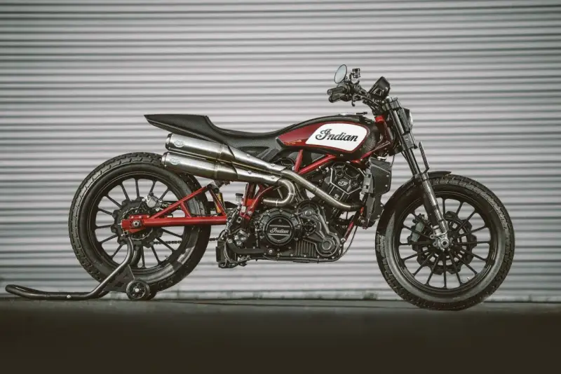 Stylowy Indian FTR 1200 w kolorze czerwono-białym, z podwójnym wydechem i czarnymi felgami, gotowy do jazdy.