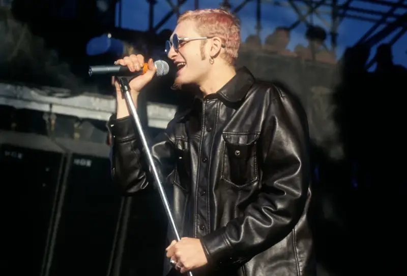 Layne Staley w skórzanej kurtce śpiewa do mikrofonu. Jego śmierć wciąż porusza fanów.