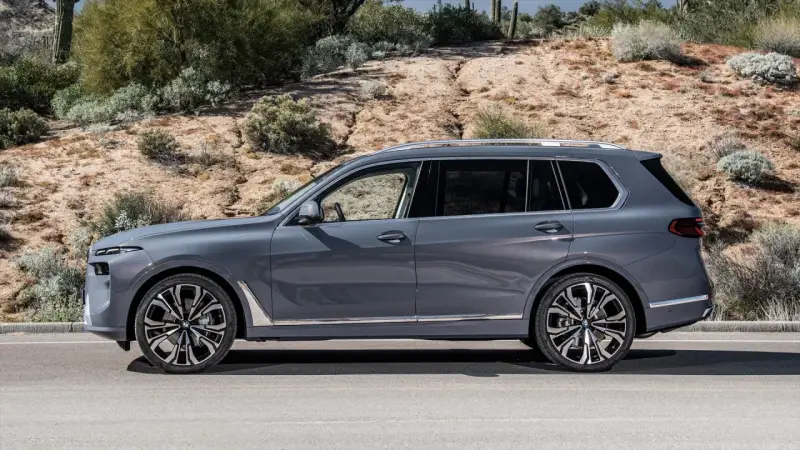Szary BMW X9 na tle pustynnego krajobrazu. Elegancki SUV z chromowanymi detalami i masywnymi felgami.