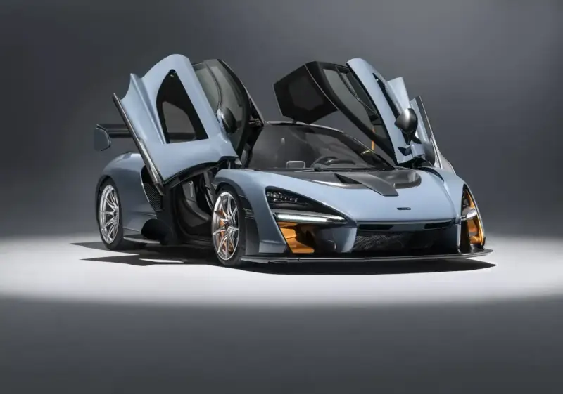 Niebieski McLaren Senna z otwartymi drzwiami, gotowy do startu.