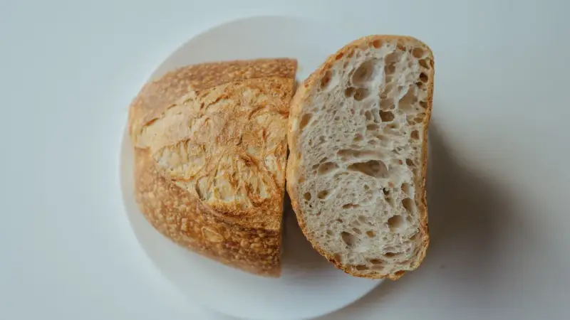 Chleb na talerzu, przekrojony na pół. Idealny przepis na szybki chleb, z chrupiącą skórką i puszystym wnętrzem.