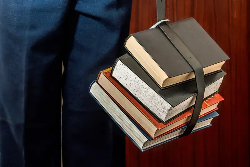 Un fascio di libri legati da una cinghia, un simbolo del percorso per capire come funzionano i CFU e il carico di studio.