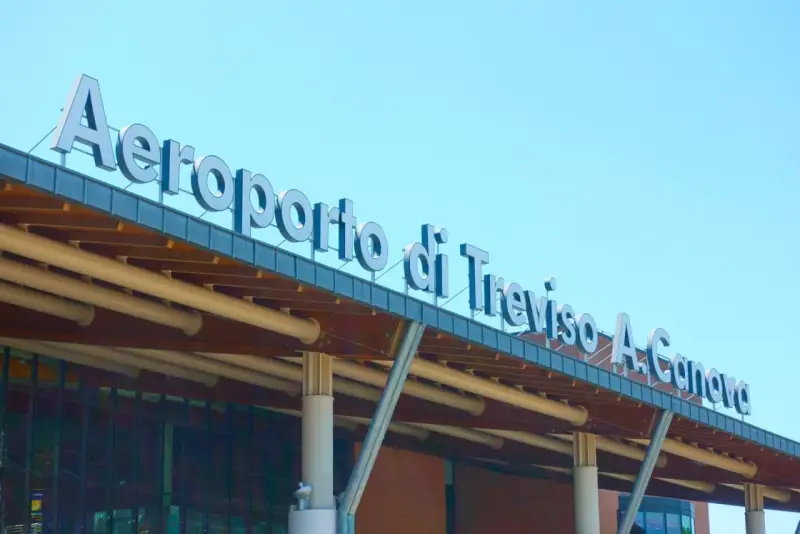 Aeroporto di Treviso A. Canova, uno dei principali aeroporti del Veneto, con insegna luminosa sotto un cielo azzurro.