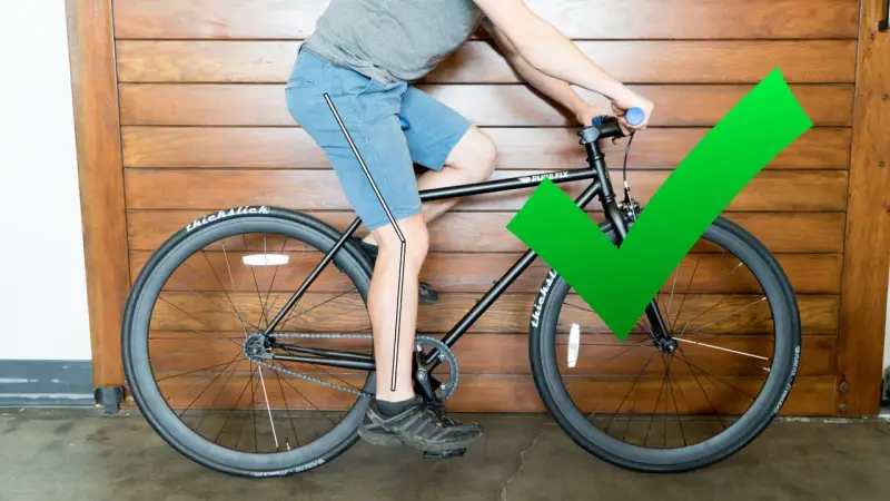 A cyclist demonstrates proper bike seat height with a slight knee bend at the bottom of the pedal stroke. A green checkmark confirms the correct adjustment.