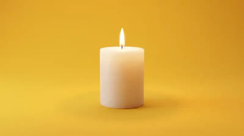 Brennende Kerze auf gelbem Hintergrund. Sie symbolisiert Hoffnung und Trost, was bei der Frage nach dem welcher pflegegrad bei palliativ wichtig ist.