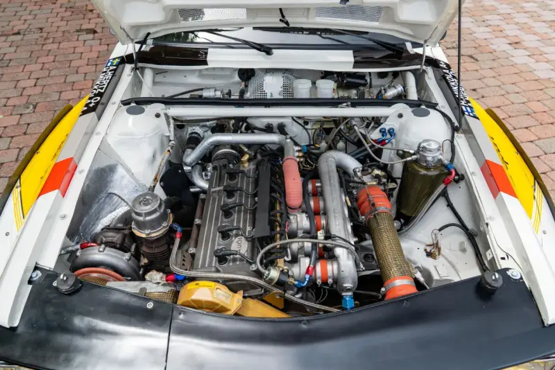 Silnik Audi quattro S1, potężna jednostka z turbosprężarką i licznymi przewodami, gotowa do rajdowych wyzwań.