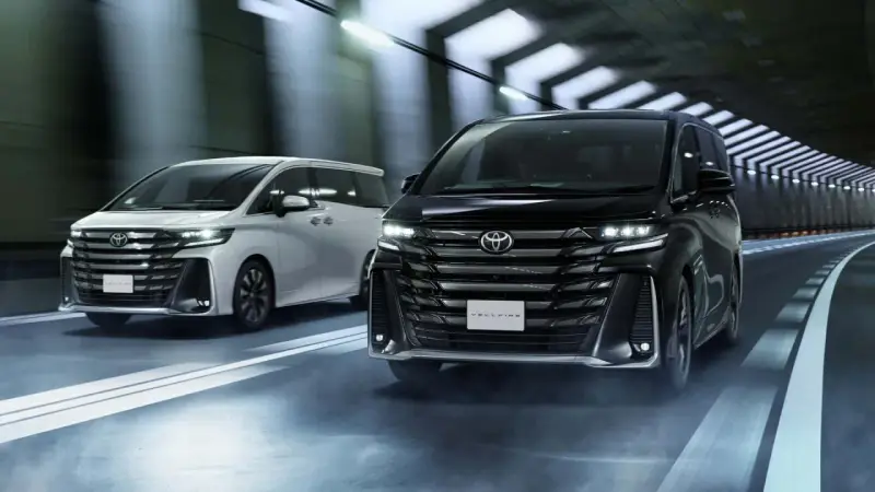 Dwa luksusowe minivany Toyota Vellfire jadące w tunelu.