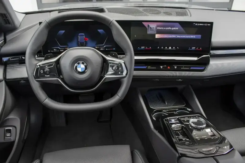 Wnętrze BMW 520d xDrive z nowoczesnym ekranem i kierownicą.