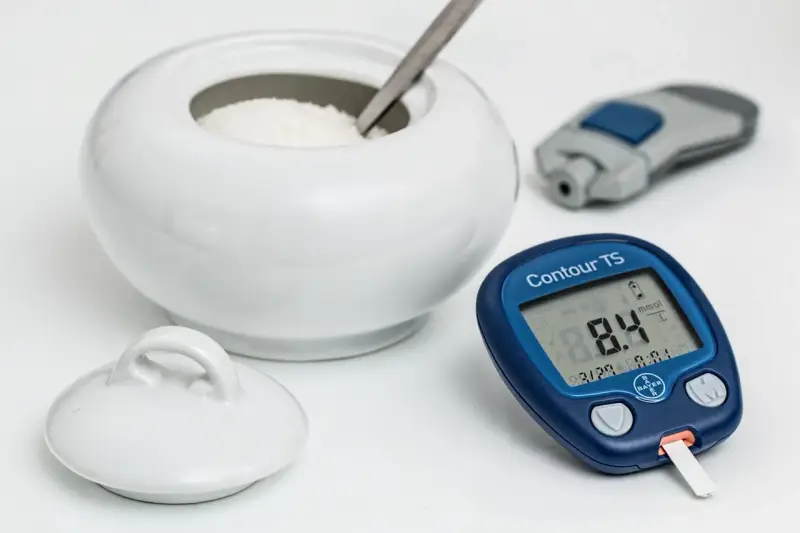 Glukometr pokazuje 8.4 mmol/L. Czy to norma dla hemoglobiny glikowanej? Obok cukiernica i nakłuwacz.