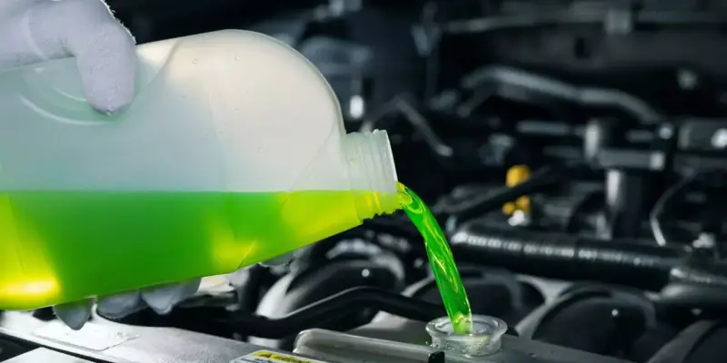 Versamento di liquido refrigerante verde in un radiatore. Le cause di un radiatore senza acqua possono essere perdite o evaporazione.