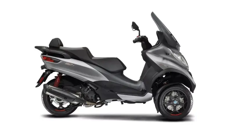 Srebrny Piaggio MP3 500, trójkołowy skuter z czarnym siedzeniem i dużą szybą. Poznaj jego piaggio mp3 500 dane techniczne.