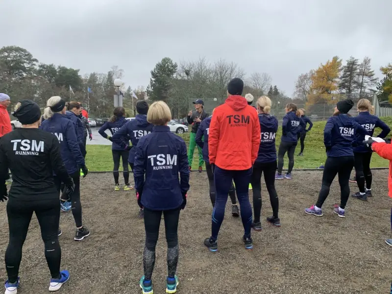 Ett team från TSM Running samlas utomhus, redo för träning.