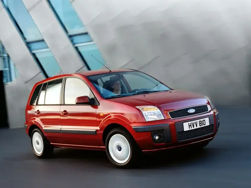 Czerwony Ford Fusion 1.4 benzyna w ruchu miejskim. Elegancka sylwetka i nowoczesny design.