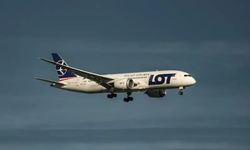 Samolot LOT Polish Airlines z bagażem podręcznym w locie, zbliżający się do lądowania.