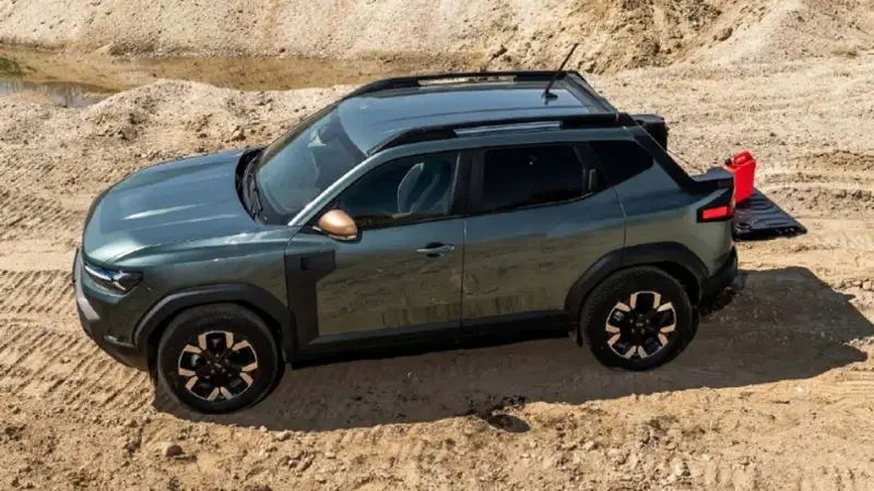 Zielony Dacia pickup z otwartą klapą bagażnika i czerwoną kanistrem na piasku.