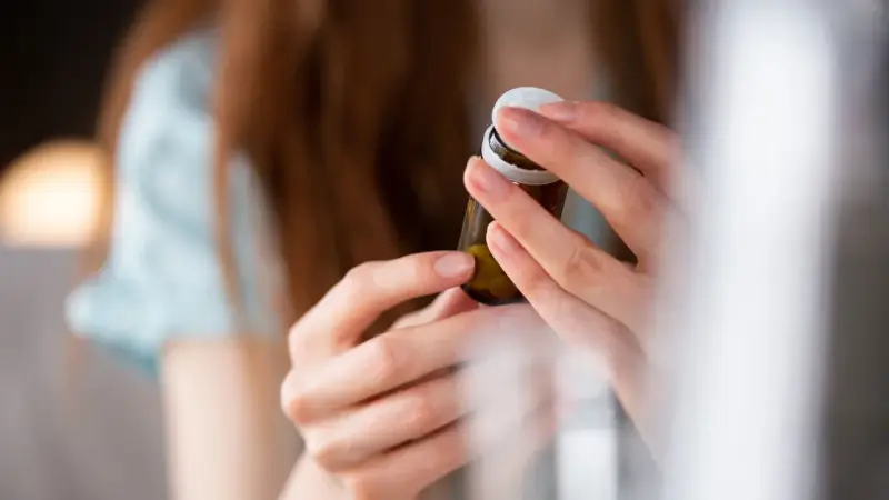 Dłonie otwierają buteleczkę z tabletkami, być może dulsevia 30, by zacząć nowy dzień.