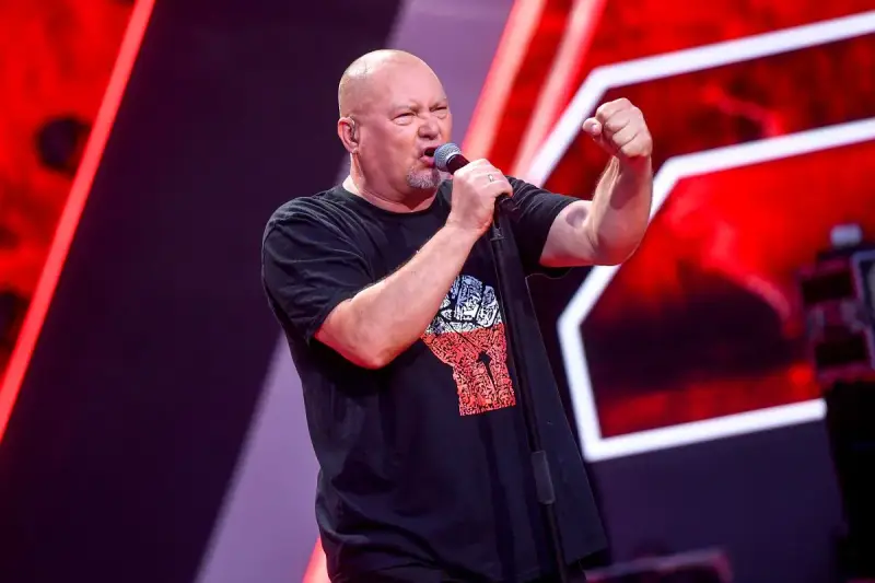 Tomasz Olejnik śpiewa z podniesioną pięścią, symbolizując siłę proletariatu.