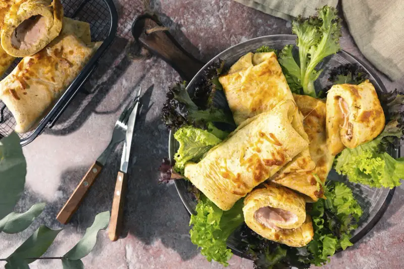 Herzhafte Pfannkuchen gefüllt mit Schinken und Käse, serviert mit frischem Salat. Ein Genuss für jeden Gaumen!