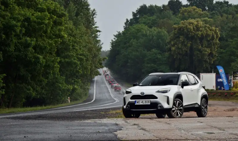 Biały crossover na poboczu drogi, w tle sznur samochodów i zielone drzewa. Trasa z Warszawy do Szczecina, ile km?