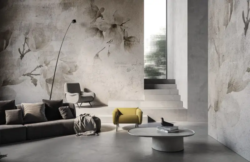 Soggiorno moderno con divano grigio, poltrone e tavolino. Le pareti sono decorate con **case con carta da parati** a tema floreale, creando un'atmosfera elegante.