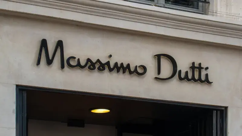 Elegancki szyld Massimo Dutti nad wejściem do sklepu. Planujesz Massimo Dutti zwroty? Sprawdź ofertę!