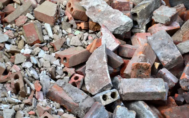 Stos gruzu budowlanego, cegieł i betonowych fragmentów. To materiał, który może być zaklasyfikowany jako gruz kod odpadu.