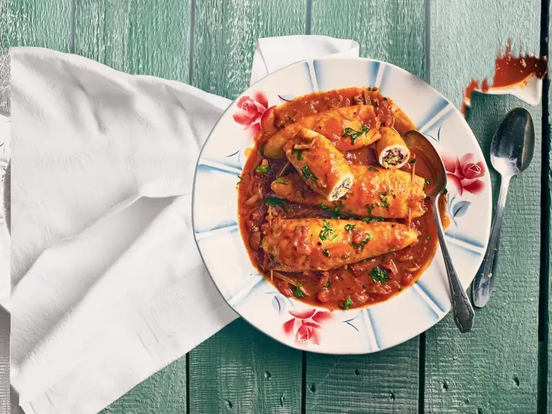 Assiette de calamars farcis à la sauce tomate, une recette encornet tomate savoureuse, garnie de persil frais.