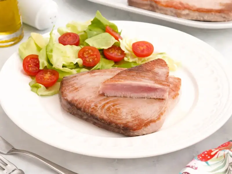 Delicioso atún a la plancha con ensalada fresca de lechuga y tomates cherry. Un plato ligero y saludable.