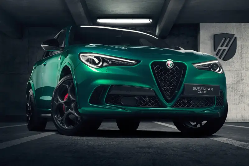 Zielony Alfa Romeo Stelvio Quadrifoglio z czarnymi felgami i czerwonymi zaciskami hamulcowymi, zaparkowany w garażu.