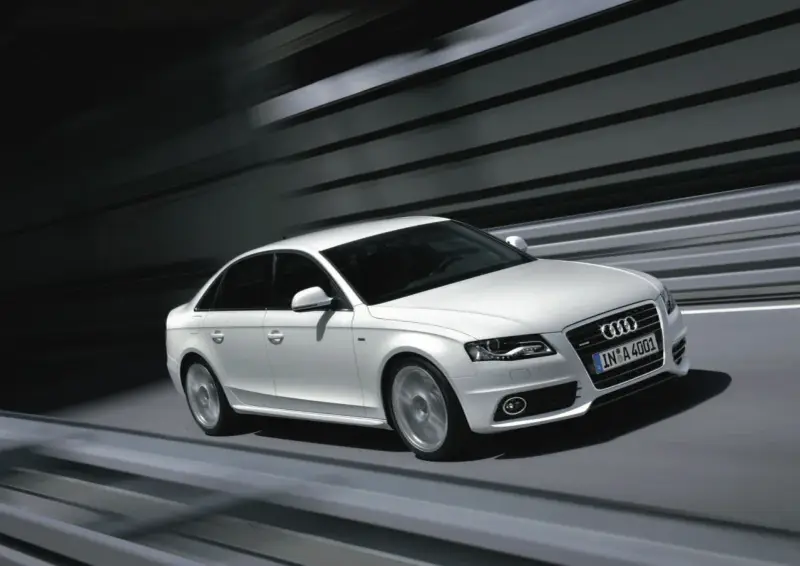 Białe Audi A4 B8 w ruchu, z rozmytym tłem. Wiele osób szuka audi a4 b8 opinie, by poznać jego zalety.
