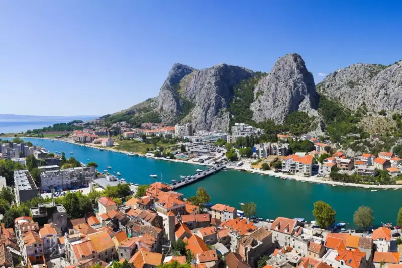 Widok na miasto Omiš w Chorwacji, gdzie rzeka Cetina wpada do morza. Piękne, turkusowe morze i góry.