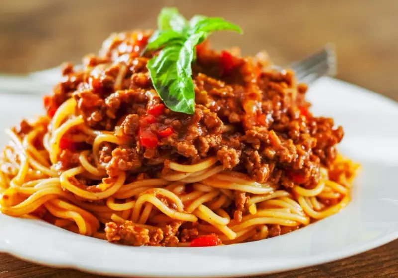 Pyszne spaghetti bolognese, idealne na prosty obiad. Aromatyczny sos mięsny z pomidorami i bazylią na złocistym makaronie.