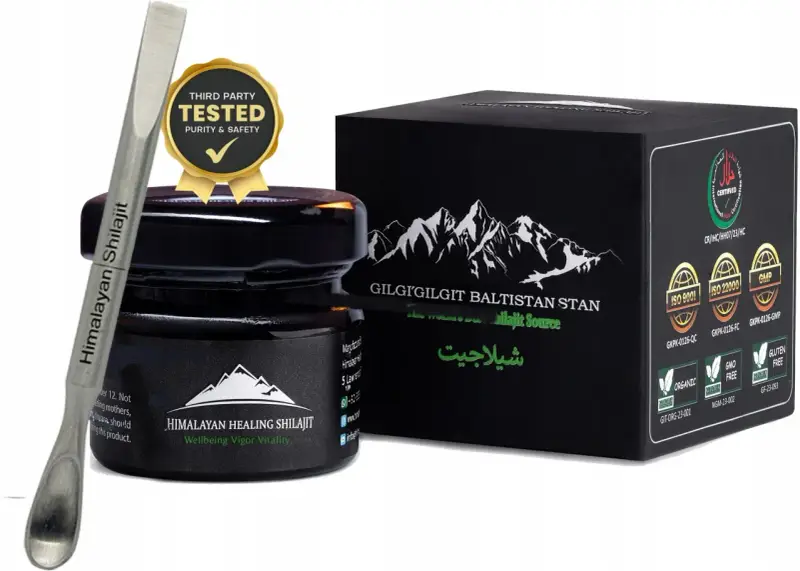 Srebrna szpatułka z napisem "Himalayan Shilajit" obok czarnego słoiczka i pudełka z górami. Certyfikaty potwierdzają jakość shilajitu.