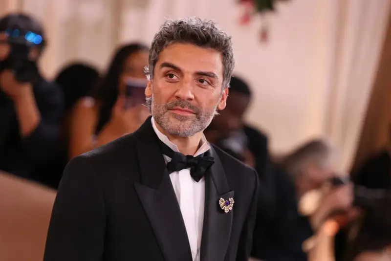 Oscar Isaac w eleganckim smokingu, gotowy na premierę swoich najnowszych filmów, seriali i programów.