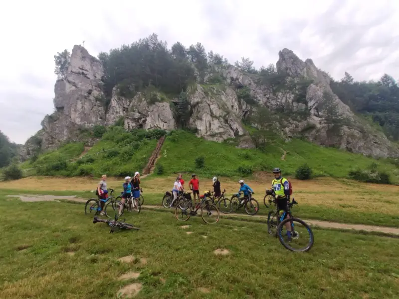 Grupa rowerzystów na tle skalnych ostańców. Jura Krakowsko-Częstochowska rowerem to wspaniała przygoda.