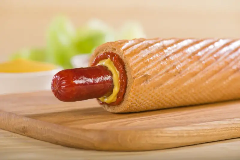 Pyszny hot dog francuski z musztardą i ketchupem, gotowy do zjedzenia.