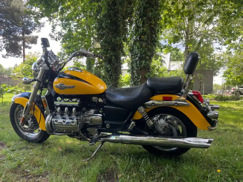 Żółta Honda Valkyrie 1500, z chromowanymi elementami i potężnym silnikiem, zaparkowana na trawie. Dane techniczne tego klasyka budzą podziw.