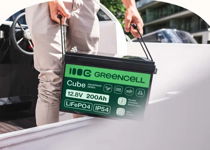 Mężczyzna niesie akumulator LiFePO4 12.8V 200Ah marki Greencell Cube. To jeden z rodzajów akumulatorów, idealny do łodzi, kamperów i wózków golfowych.