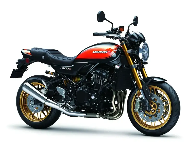 Stylowy motocykl Kawasaki Z900RS w kolorze czarnym z pomarańczowymi akcentami i złotymi felgami. Klasyka w nowoczesnym wydaniu.