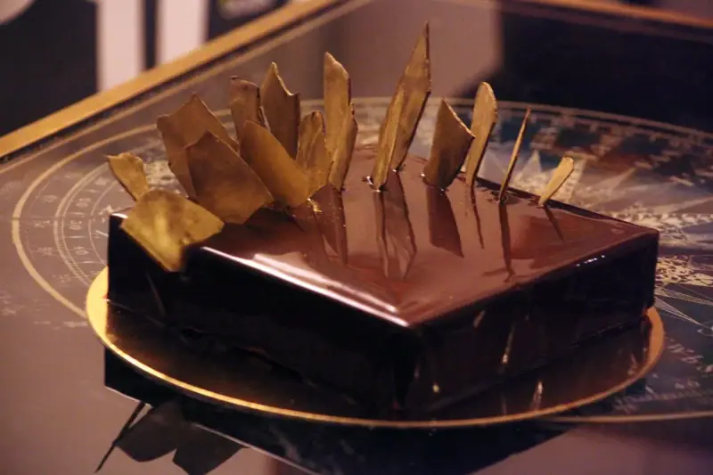 Gâteau royal chocolat Michalak, un délice glacé aux éclats dorés, prêt à être dégusté.