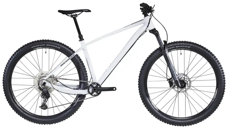 Biały rower hardtail z szerokimi oponami i amortyzatorem RockShox, gotowy na terenowe wyzwania.