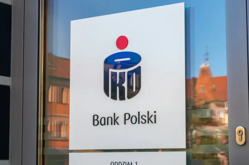 Logo PKO Bank Polski na drzwiach. W tle odbicie kamienicy.
